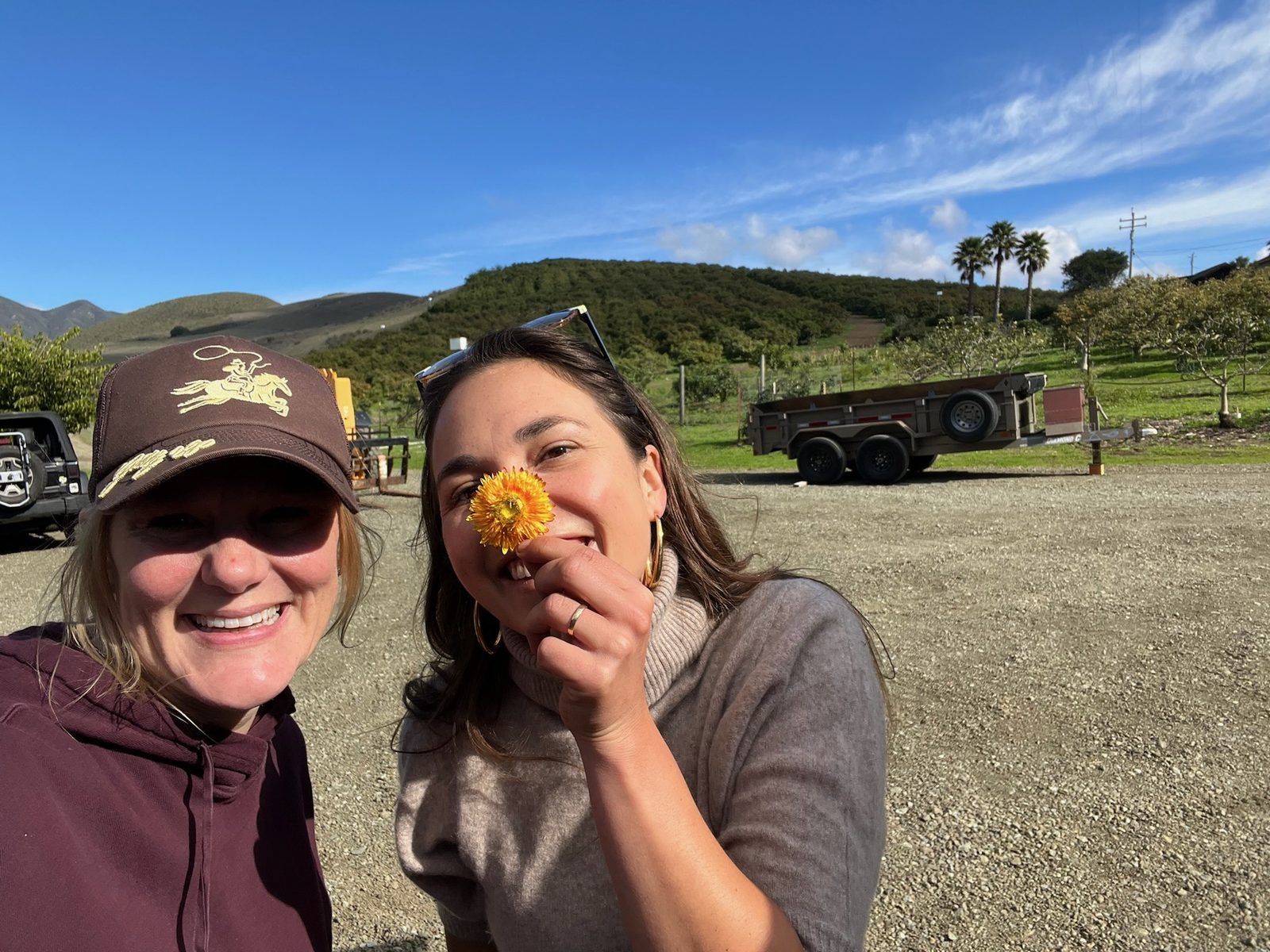 Kellie and Amelie at Pico Blooms, a yellow strawflower in hand